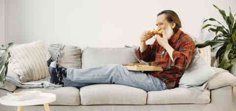Older man eating pizza