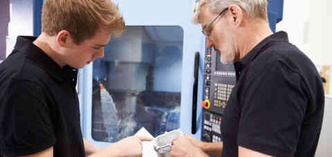 Male apprentice working with engineer on