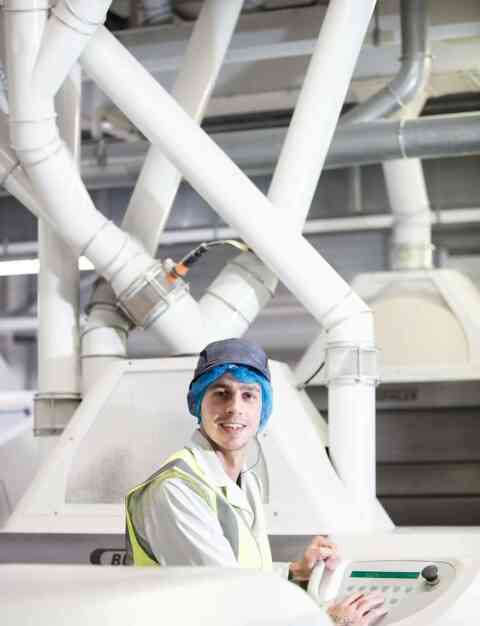 Young man operating mill machinery